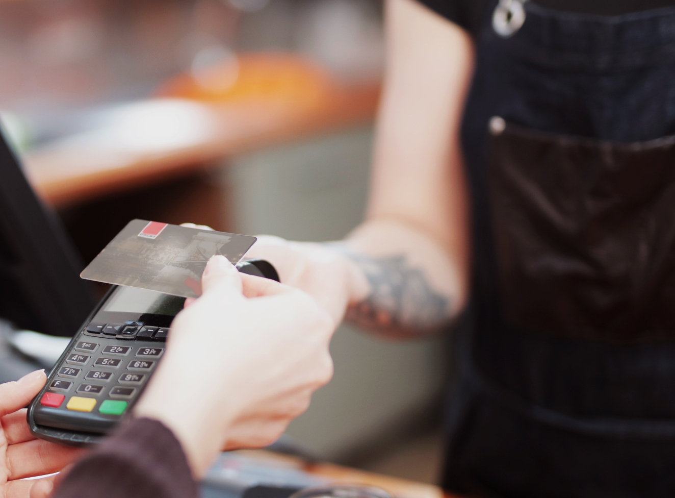 Person beim Bezahlen mit Kreditkarte